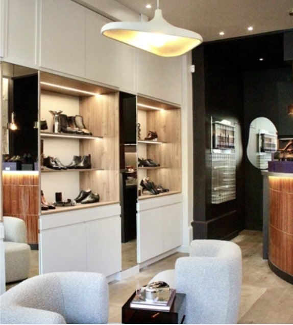 Salon d'essayage de la boutique : fauteuils en bouclette, niches éclairées en bois, comptoir arrondi en tasseaux