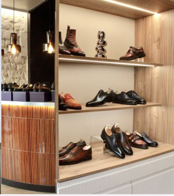 Étagères en bois éclairées présentant des souliers patinés